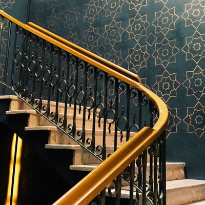 An ornate staircase with intricate patterns on the wall behind it